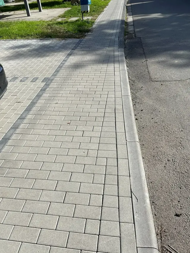 Entwässerungsrinne zwischen Pflasterfläche und Straße