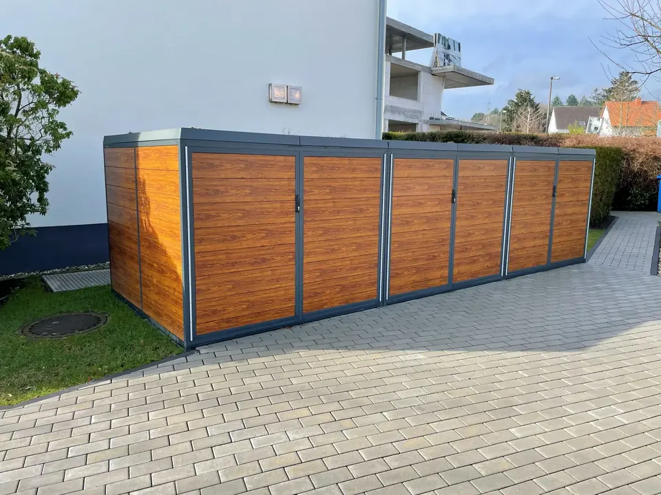 Sichtschutzelemente aus Holz in Metallrahmen entlang einer Außenfläche